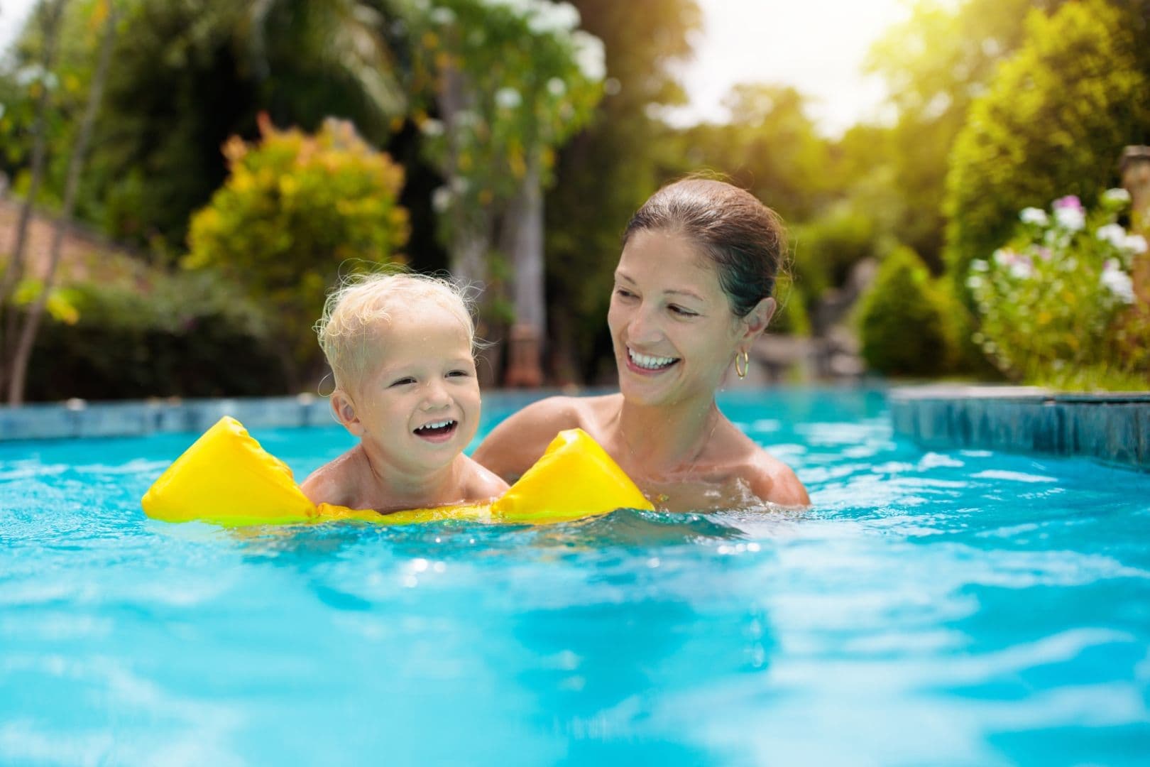 A parent and child in a swimming pool.